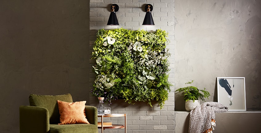 Wall-mounted grow lights above an indoor vertical garden