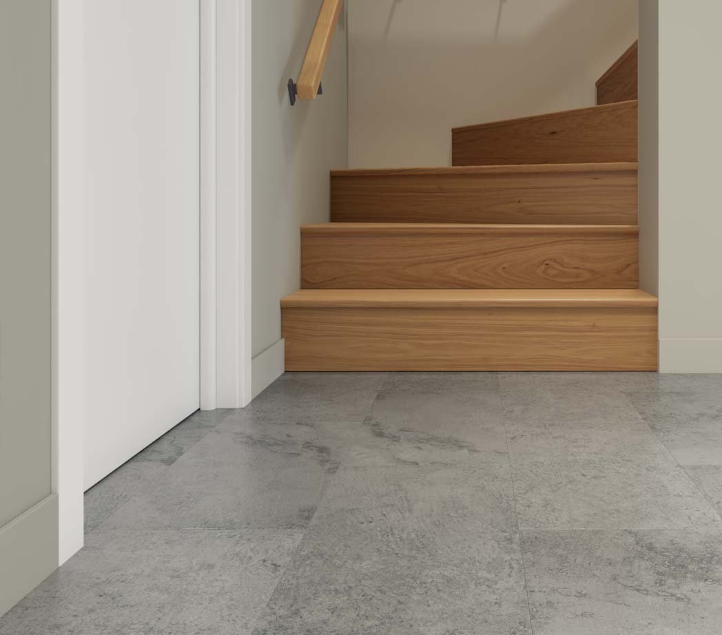 Wooden stairs leading to a basement with grey flooring