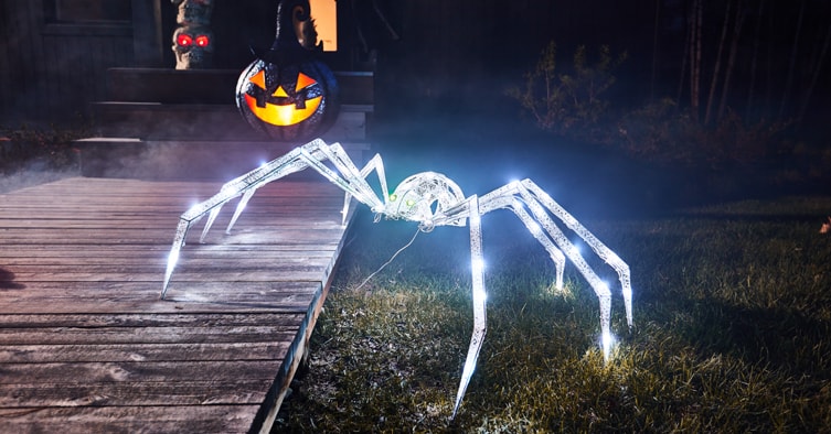 Araignée géante illuminée sur une pelouse pour l’Halloween