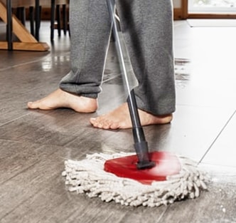 Person cleaning a tile floor with a mop