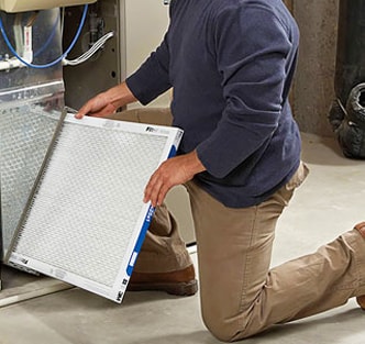 Person replacing furnace filters