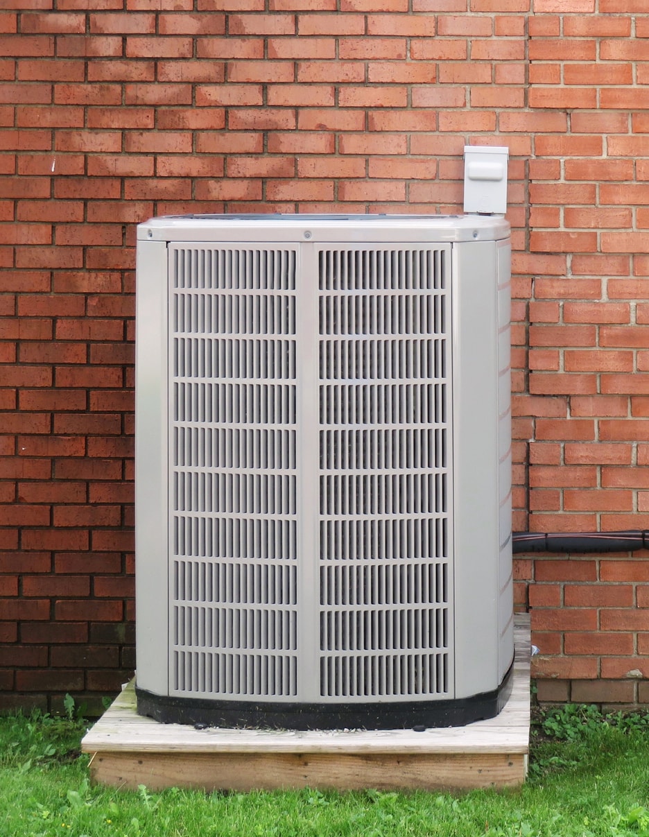 Air conditioning unit in front of a brick wall