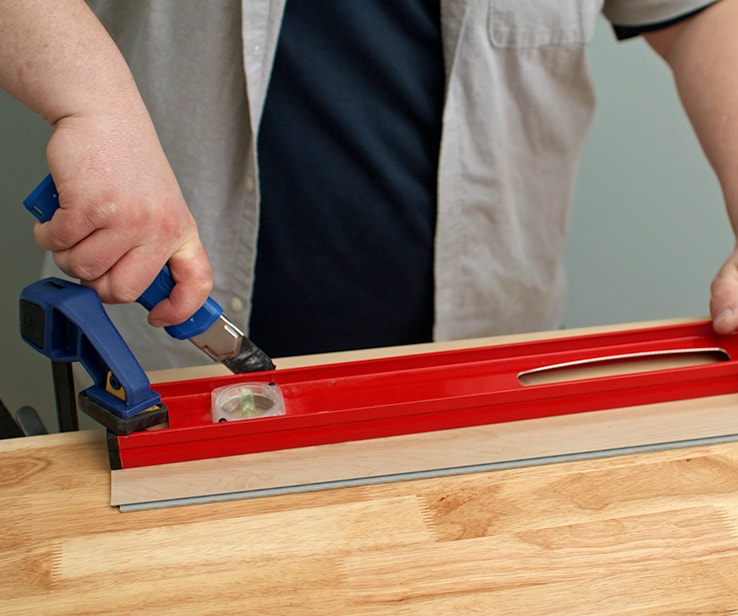 Man cutting a vinyl plank horizontally