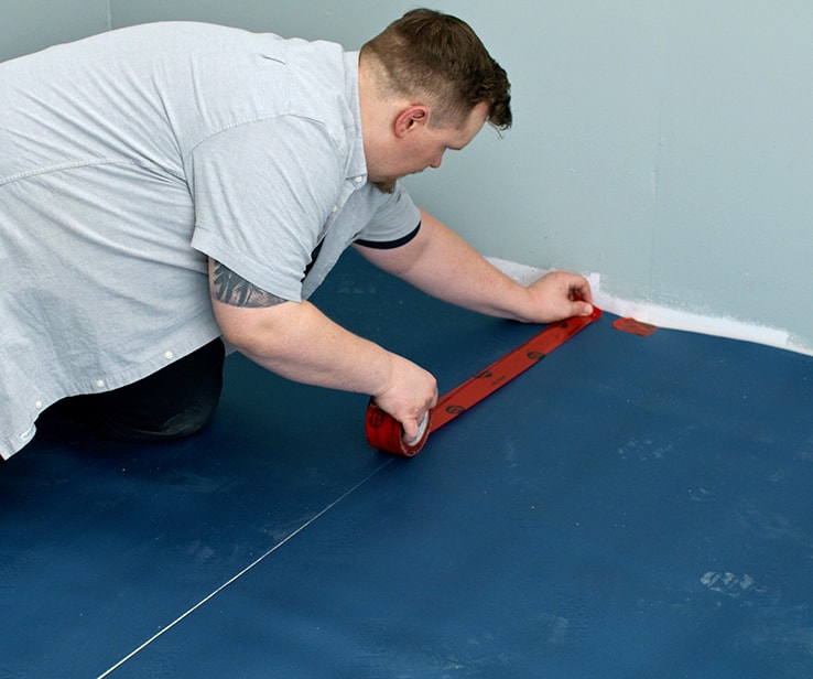 Man taping floor underlayment