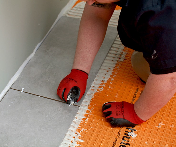 Man inserting tile spacers