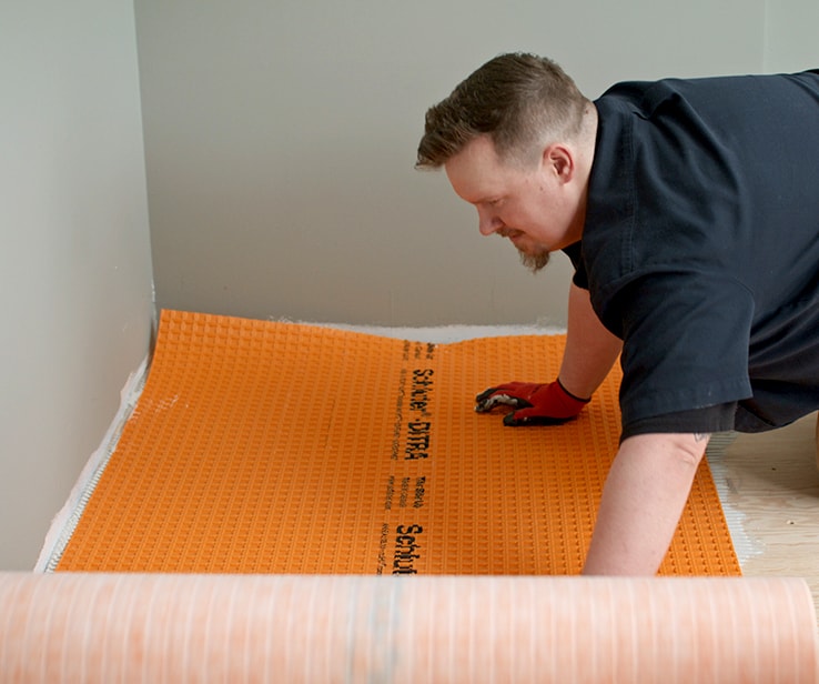 Man laying a floor membrane