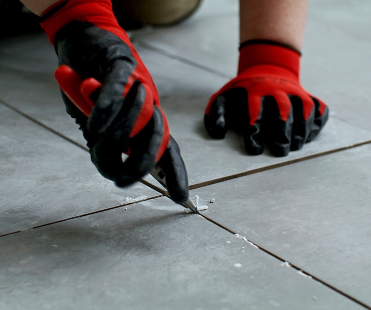 Man removing tile spacers